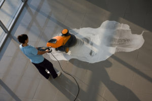 A worker is cleaning the floor with machine